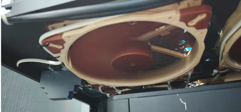 The same fans mounted under the shelf, blowing up at the cases